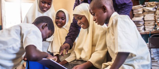 African children using a laptop inside classroom